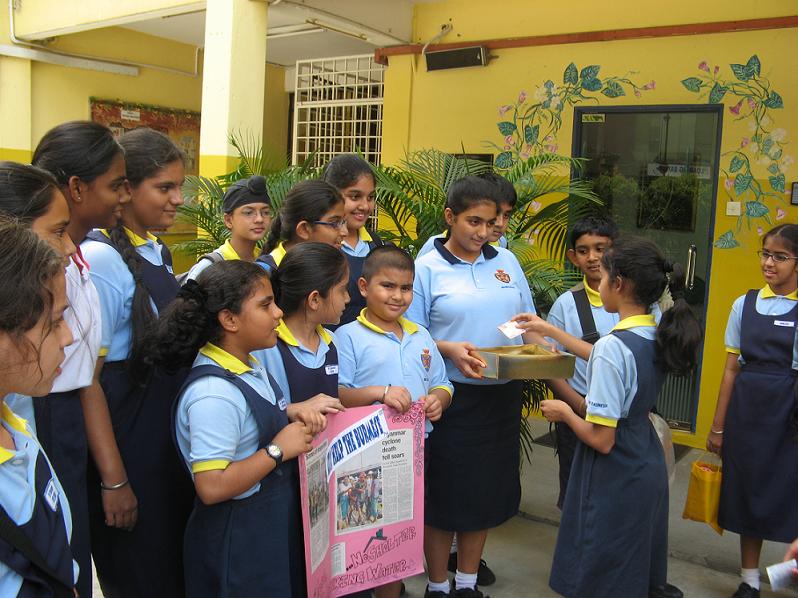 Anmol Shah of Primary 6 giving her generous donation