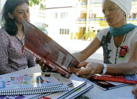 Jaswinder Kaur (right) shows the book on leadership to Sarjit Kaur. Pic by Farizul Hafiz Awang Muhammad